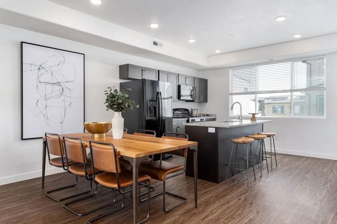 A modern kitchen with a wooden table and chairs.