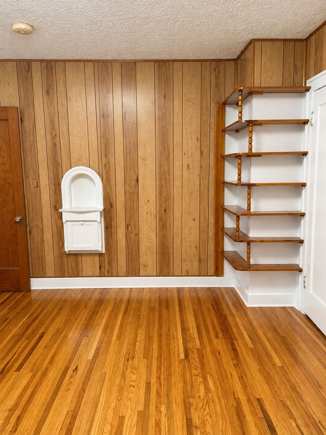 A room with wooden walls and a white door.