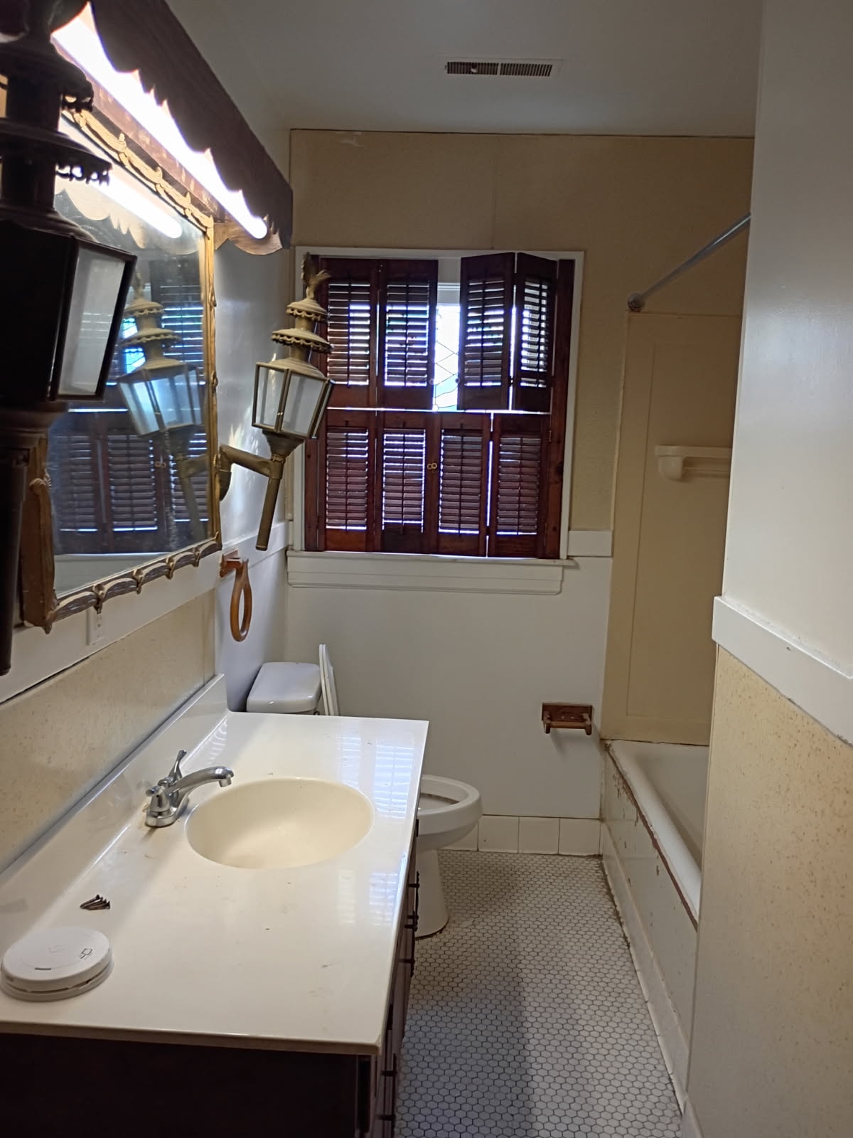 A bathroom with a sink, mirror, and toilet.