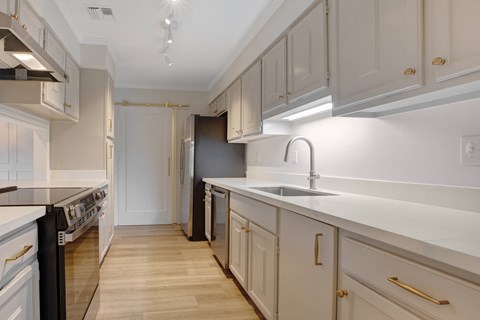 A kitchen with white cabinets and a black dishwasher.
