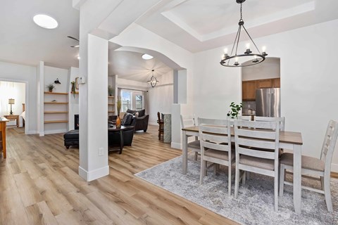 A dining room with a wooden table and chairs.