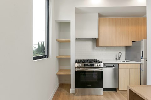 A modern kitchen with a stove and a refrigerator.