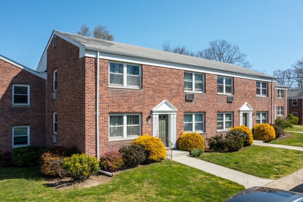 A red brick building with a white door and windows.