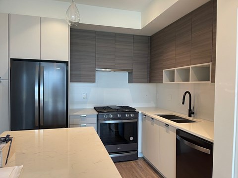 A modern kitchen with a black refrigerator and stove.