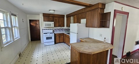 A kitchen with white appliances and wooden cabinets.