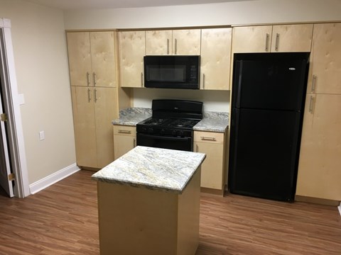 A kitchen with wooden cabinets and black appliances.