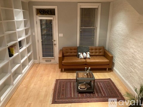 A living room with a brown couch and a coffee table.