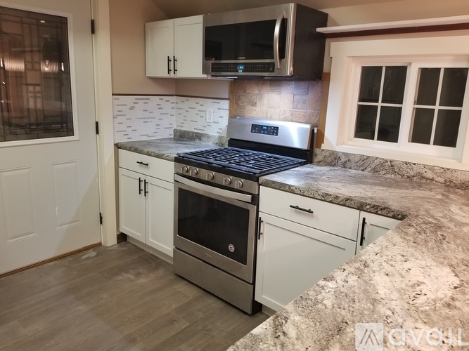 A kitchen with a stove top oven and microwave above it.