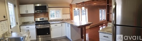 A kitchen with a granite counter top and stainless steel appliances.