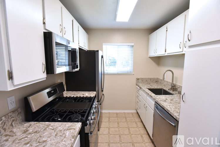A kitchen with black appliances and white cabinets.
