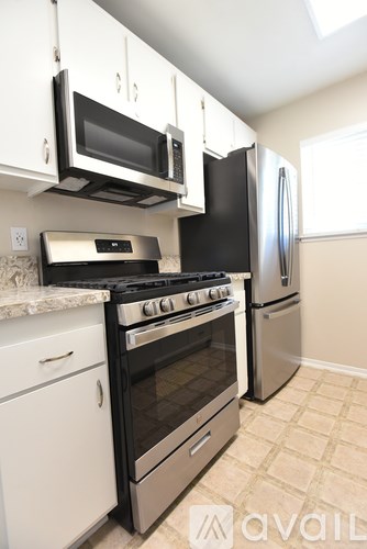 A kitchen with white cabinets and black appliances.