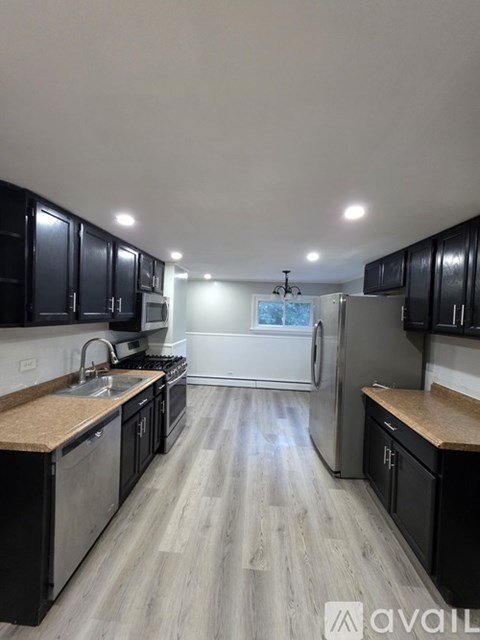 A kitchen with black cabinets and a wooden countertop.