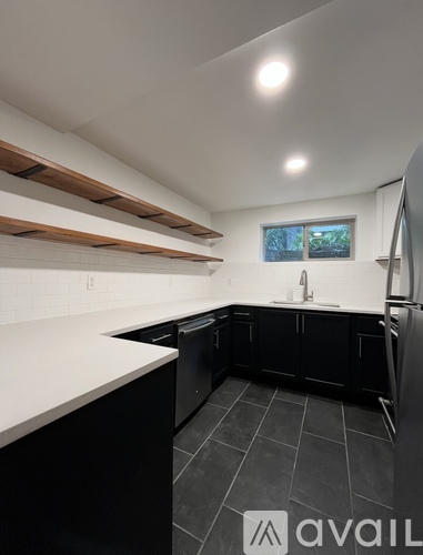 A kitchen with black cabinets and a window.