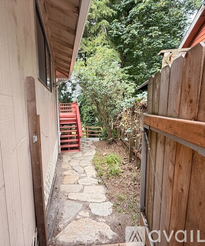A narrow alley with a stone pathway and wooden fences.