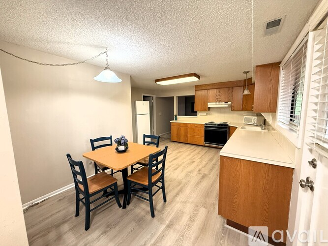 A dining room with a table and chairs.