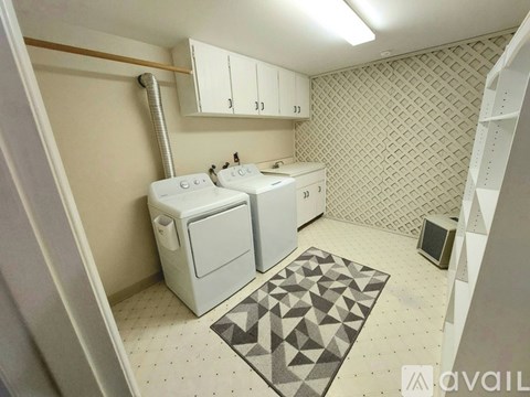 A kitchen with wooden cabinets and a black dishwasher.