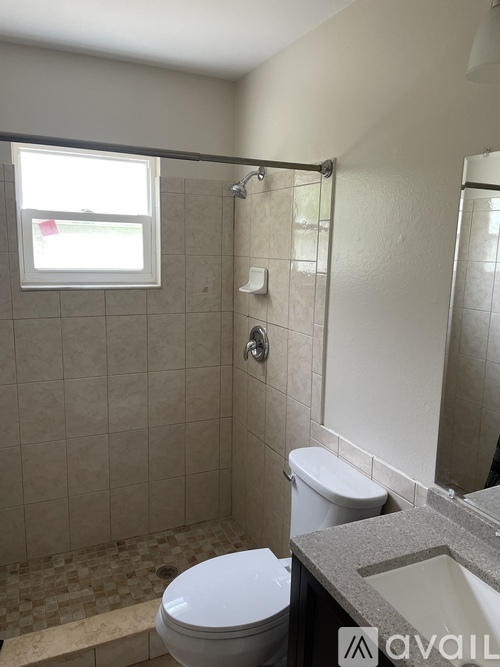 A bathroom with a toilet, sink, and shower.