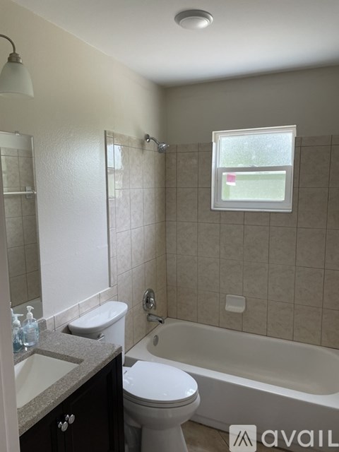 A bathroom with a toilet, sink, and bathtub.