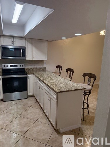 A kitchen with a granite countertop and a microwave above the stove.