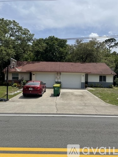 A house with a red car parked in front.