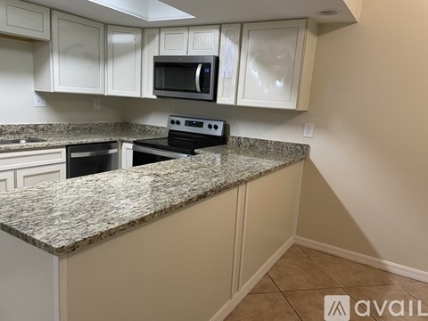 A kitchen with granite countertops and white cabinets.