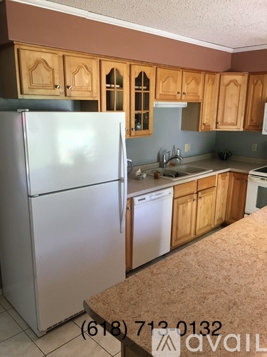 A kitchen with wooden cabinets and a white fridge.