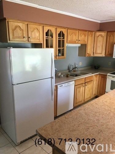 A kitchen with wooden cabinets and a white fridge.