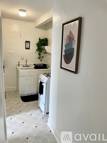A small white kitchen with a fridge, sink, and stove.