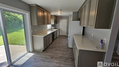 A kitchen with a white refrigerator and wooden floors.