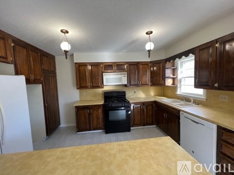 A kitchen with wooden cabinets and a black stove top oven.