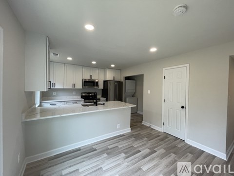 A kitchen with white cabinets and a countertop is shown.