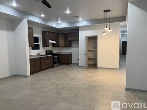 A spacious kitchen with brown cabinets and a tiled floor.