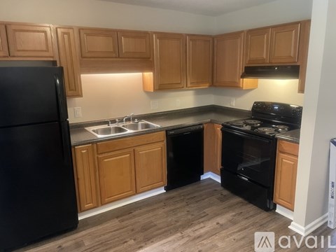A kitchen with wooden cabinets and black appliances.