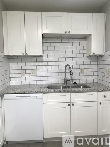 A kitchen with white cabinets and a granite countertop.