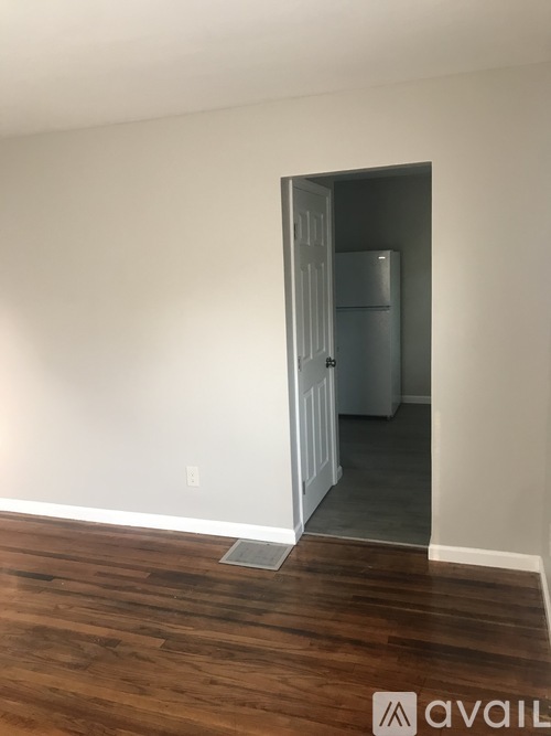 A room with a wooden floor and a white door.