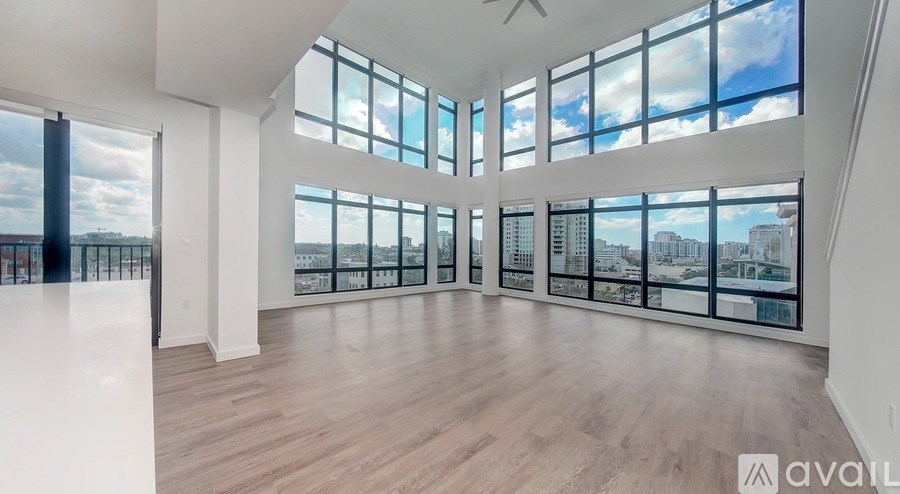 A spacious room with large windows overlooking a cityscape.