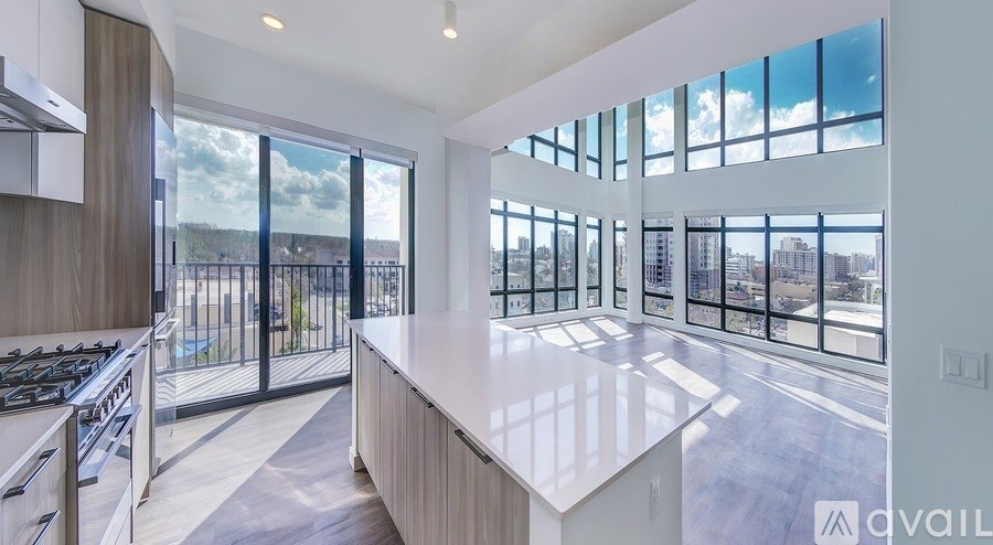 A modern kitchen with a large island and a view of the city.