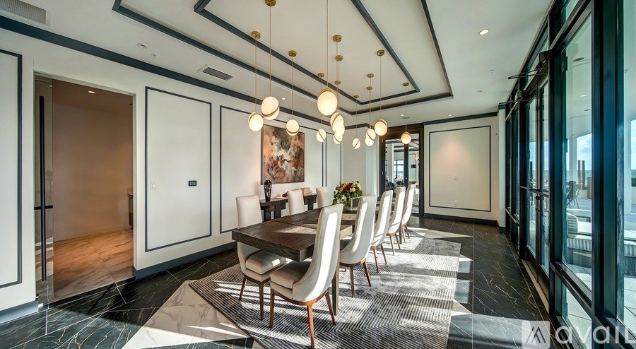 A modern dining room with a long table and chairs.