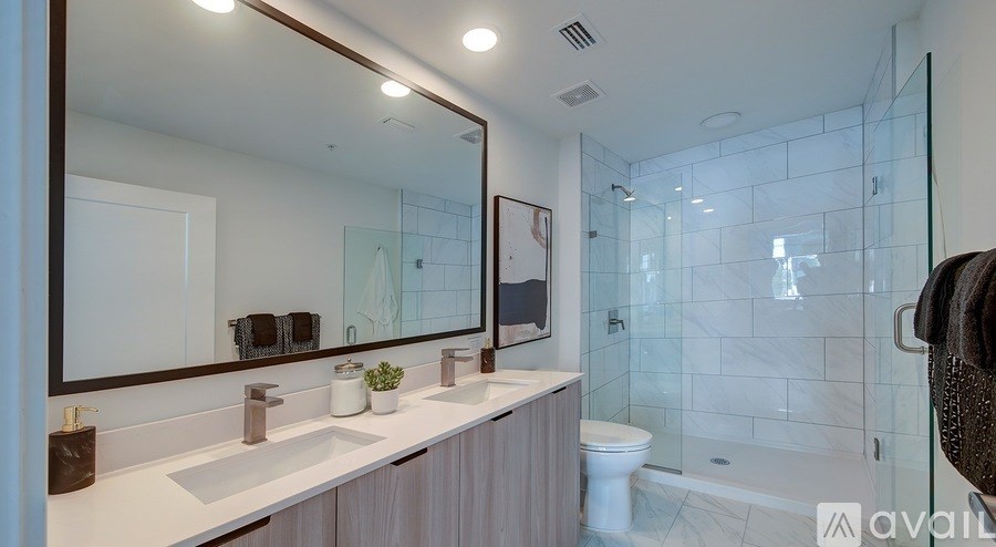 A modern bathroom with a large mirror and a glass shower area.