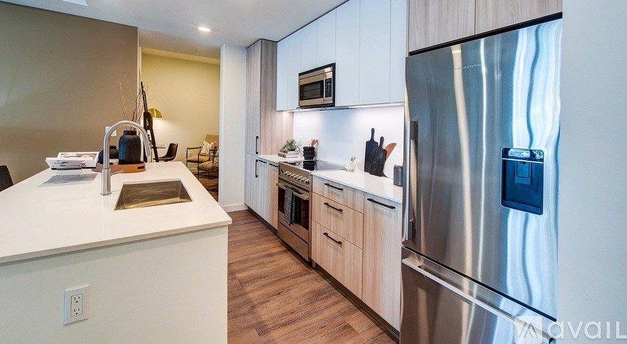 A modern kitchen with a stainless steel refrigerator and wooden cabinets.