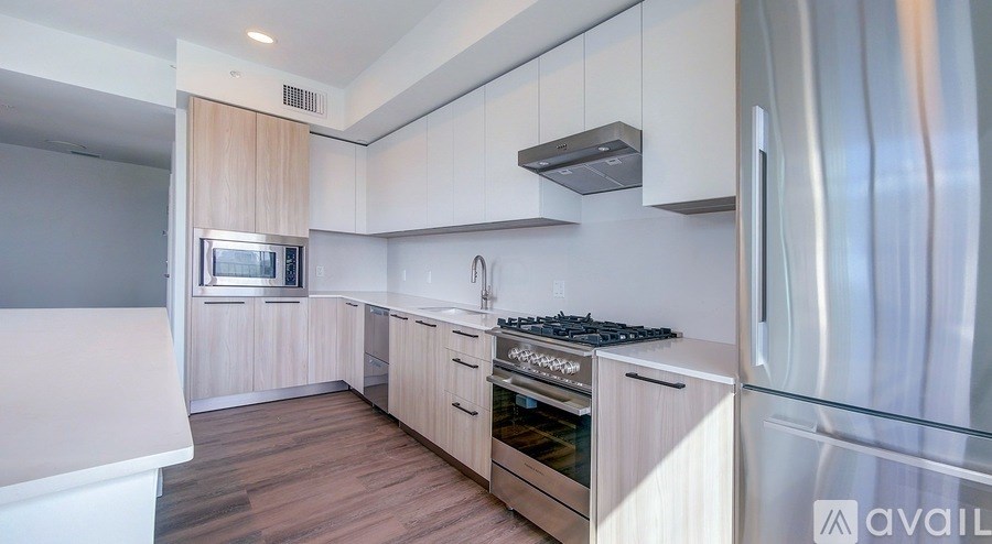 A modern kitchen with stainless steel appliances and wooden cabinets.