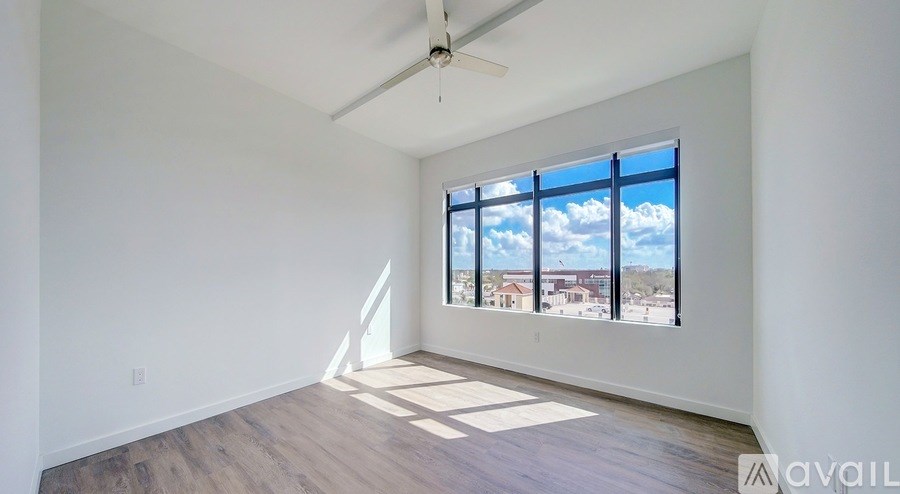 A room with a large window overlooking a residential area.