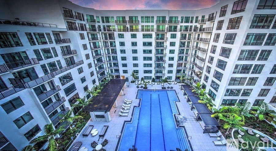 A large white building with a pool in the middle of the courtyard.