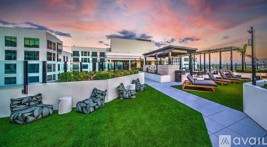 A modern building with a lush green lawn and a seating area.