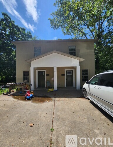 A house with a white car parked in front.