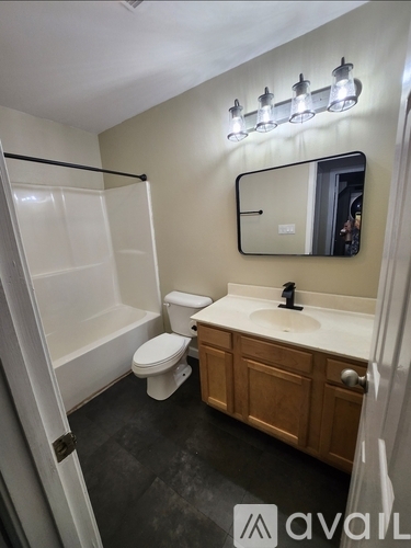 A bathroom with a white toilet, sink, and mirror.