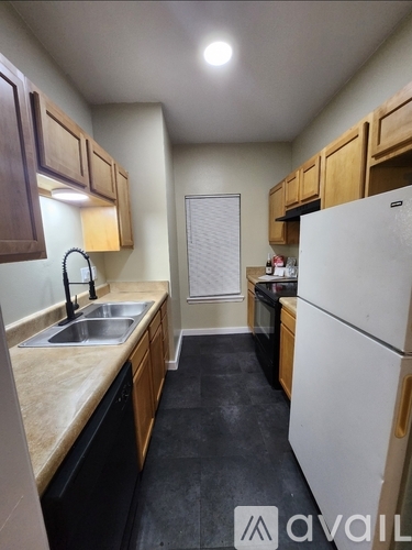 A kitchen with a white fridge and wooden cabinets.