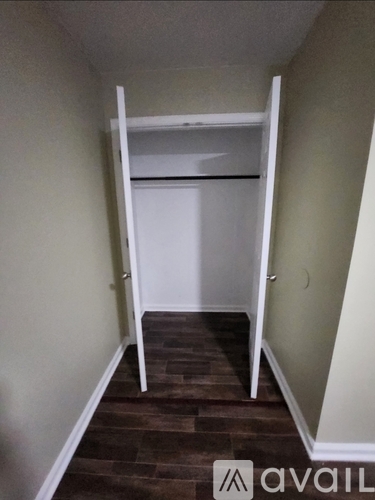A room with a white closet and a brown floor.