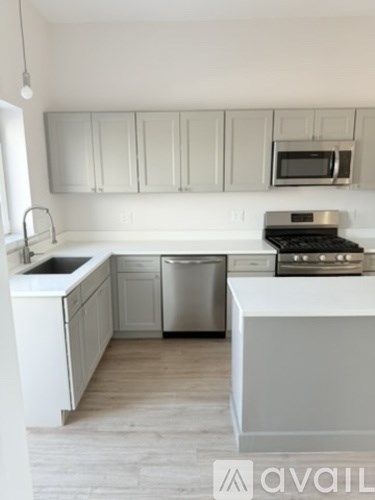 A kitchen with white cabinets and a white island.