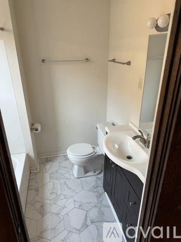 A white toilet sits in a bathroom next to a sink.